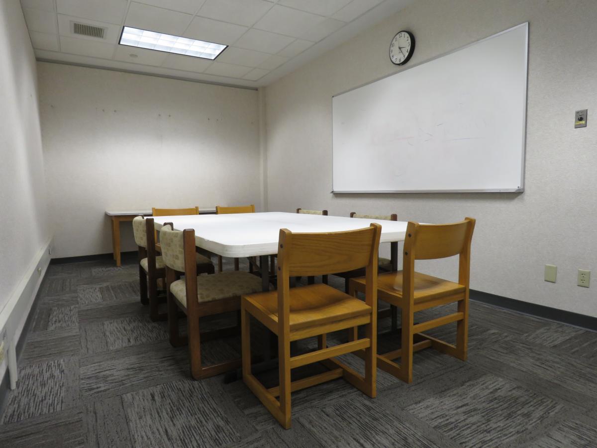 Study space with table, eight chairs and dry erase board